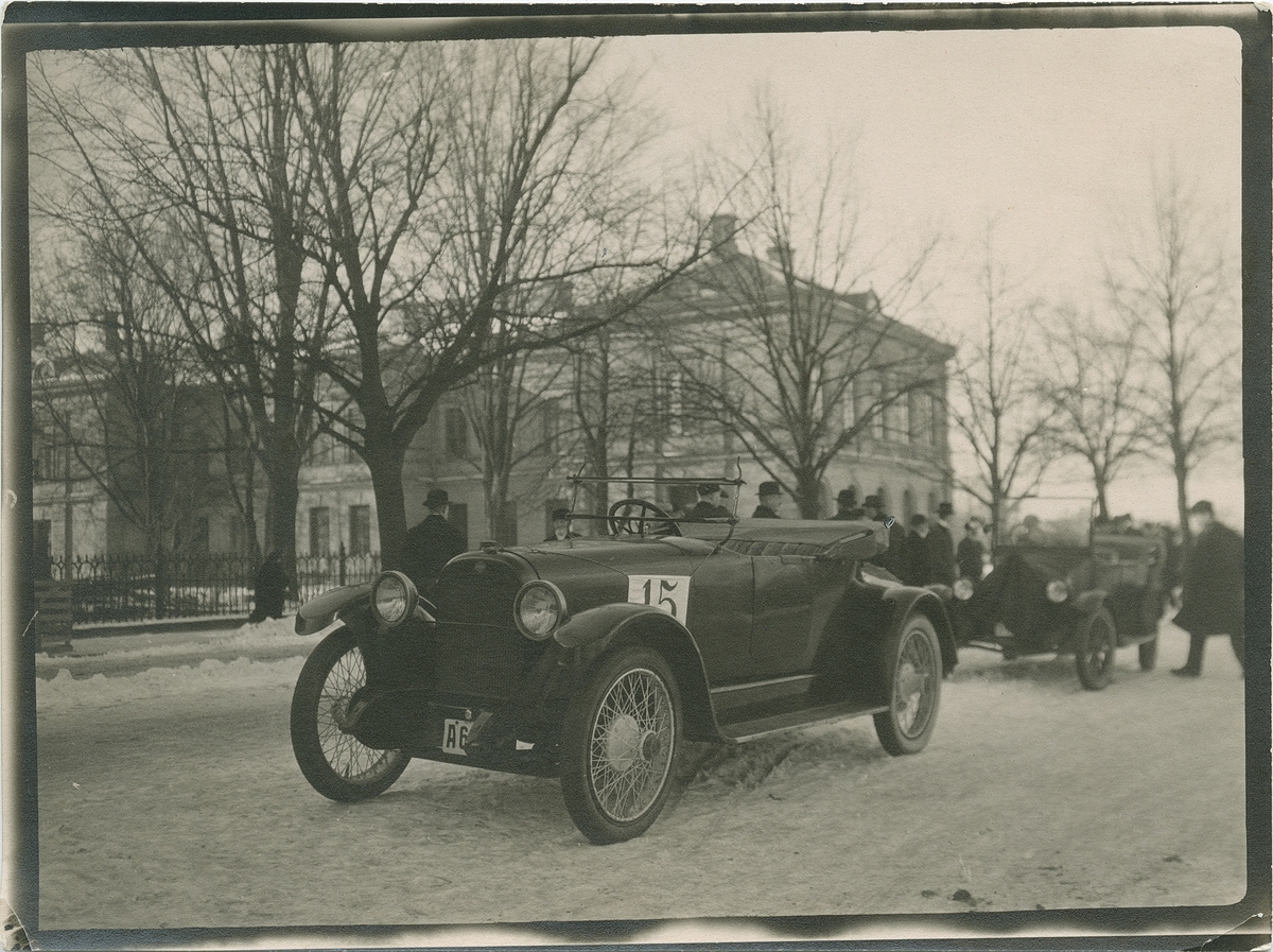 Bil under en biltävling med människor i bakgrunden.
Fotografi från John Neréns motorhistoriska samling.