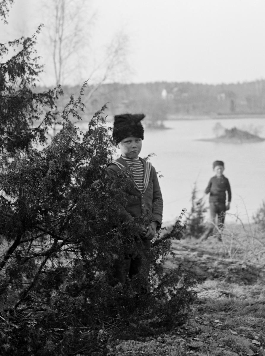 Uno Hallin med den yngsta brodern Sigurd i bakgrunden. Rimligtvis är fotot taget vid morbrodern Emil Durlings hem Strömmen i Sankt Anna.