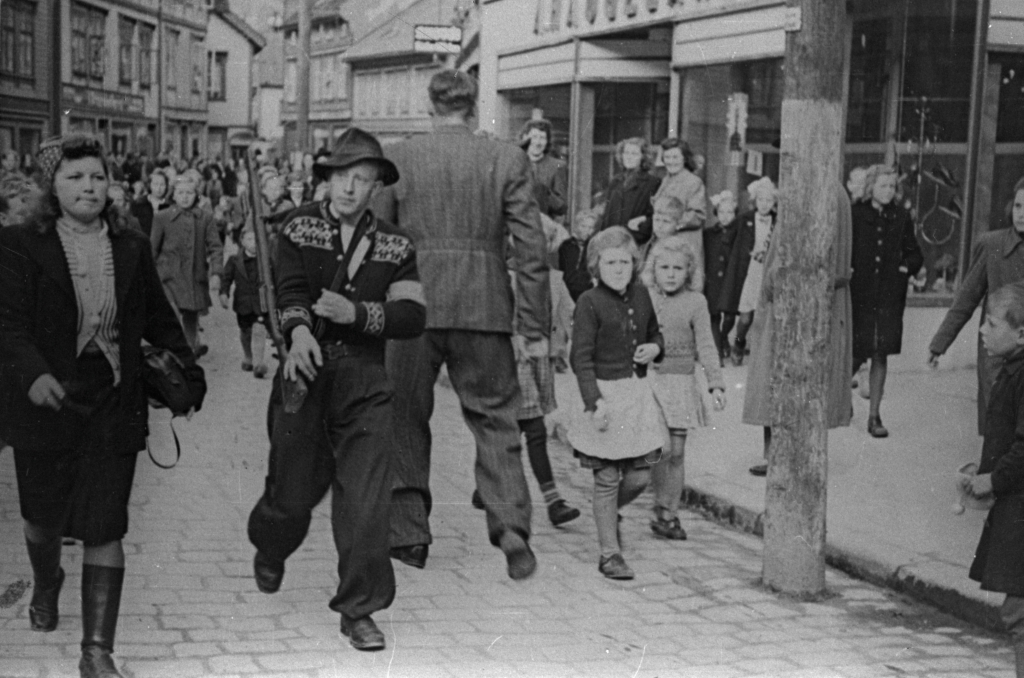 Mauritz Sørensen m/ arrestert nazist utenfor Haugelands skoforretning i Storgaten, 10. mai 1945.