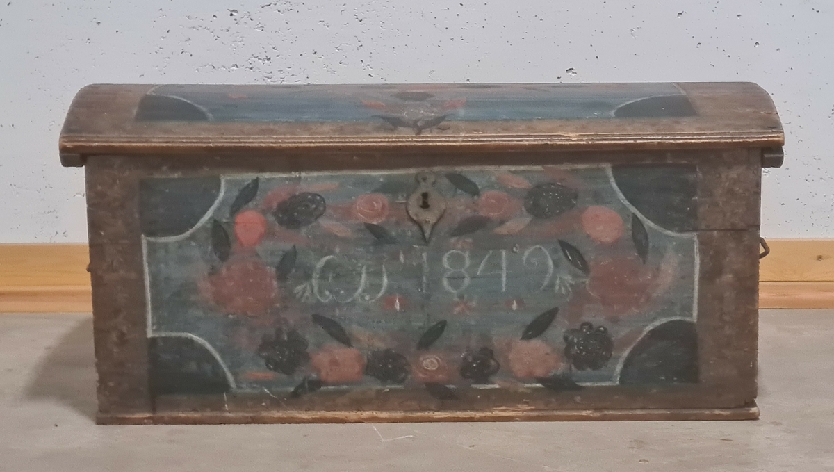 Träkista med målad dekor. På framsidan av kistan finns initialerna CSS skrivet samt årtalet 1849.

Bilaga finns.