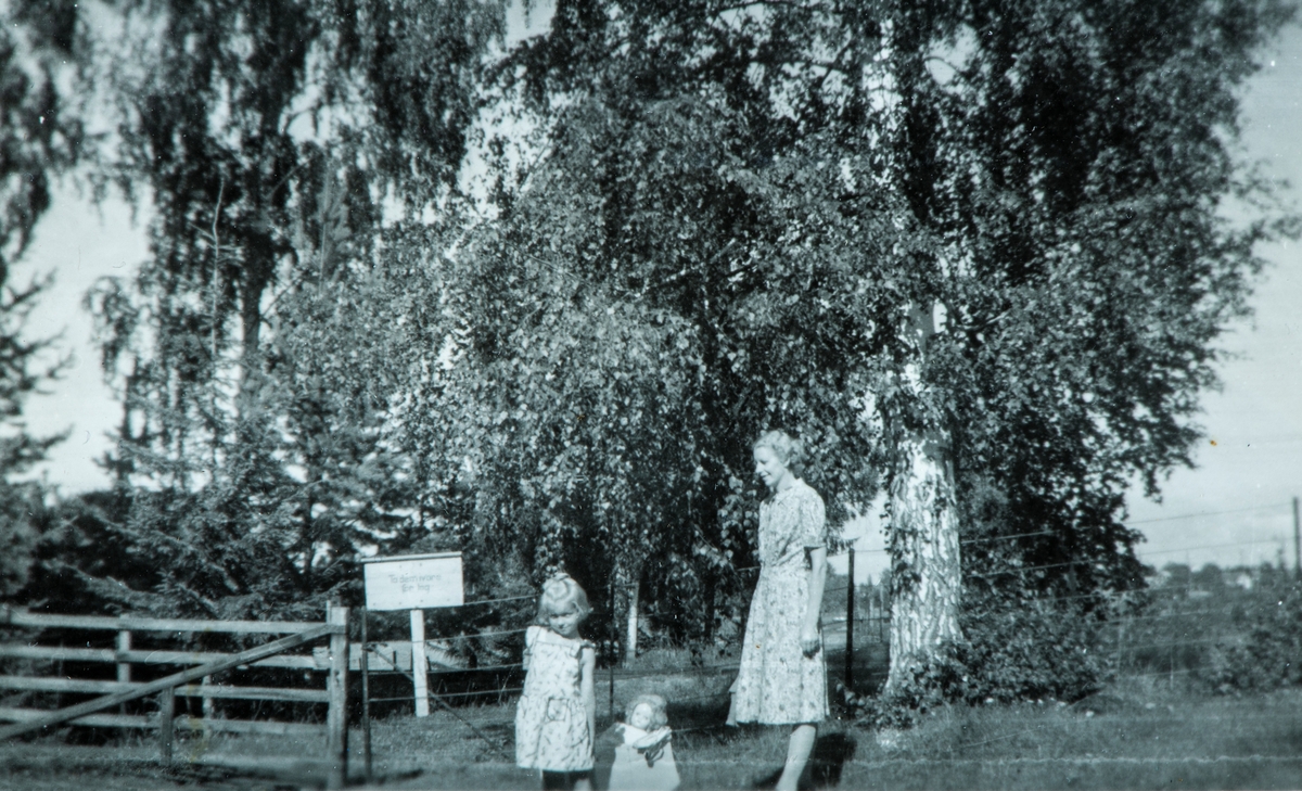 Mor og datter ute på rusletur. Anne Marie Paulsen sammen med sin dukke og sin mor, Maren Martinsen. På rusletur nær jernbanelinja ved Dalby i Ottestad, 1950.