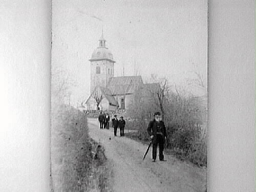 Människor som går på vägen från en kyrka någonstans i Halland.