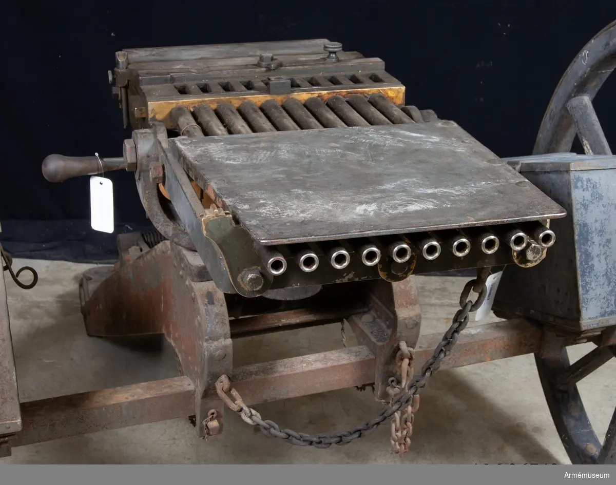 Grupp E IV a.

Detta är den första tillverkade kulsprutan av Palmcrantz & Winborg m/1875. Dock finns inget skrivet på tillverkningsplåten med uppgifter om tillverkare och år. Däremot syns tillverkningsnumret.
Magasin saknas liksom patronledare och verktyg. Se stämpel på insidan av verktygslådans lockstöd.