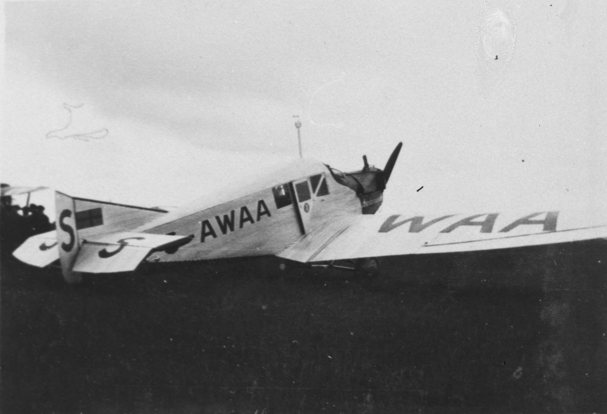 Civilt flygplan Junkers F 13 registreringsnummer S-AWAA tillhörande AB Aerotransport står på ett flygfält. Vy bakifrån.