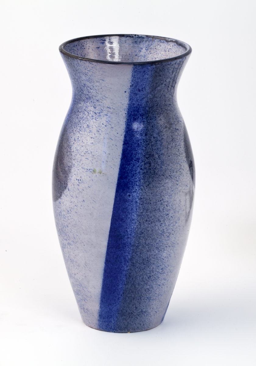 En elegant og sklank vase hvis dekorvirkning oppstår av fire glasurfelt , hvor glasuren toner fra dyp blå til lys violett, nesten med et rosa skjær. Dette repeteres i hvert felt. Underglasuren er gråaktig og er sprøytemalt på korpus. Den toner fra mørk til lys. Den har klare ovrglasureer, som skaper dekorvirkningene i glasuren.  På  hver side av vasen, i skjæringspunktet mellom to glasurfelt, er det en grå sirkel.