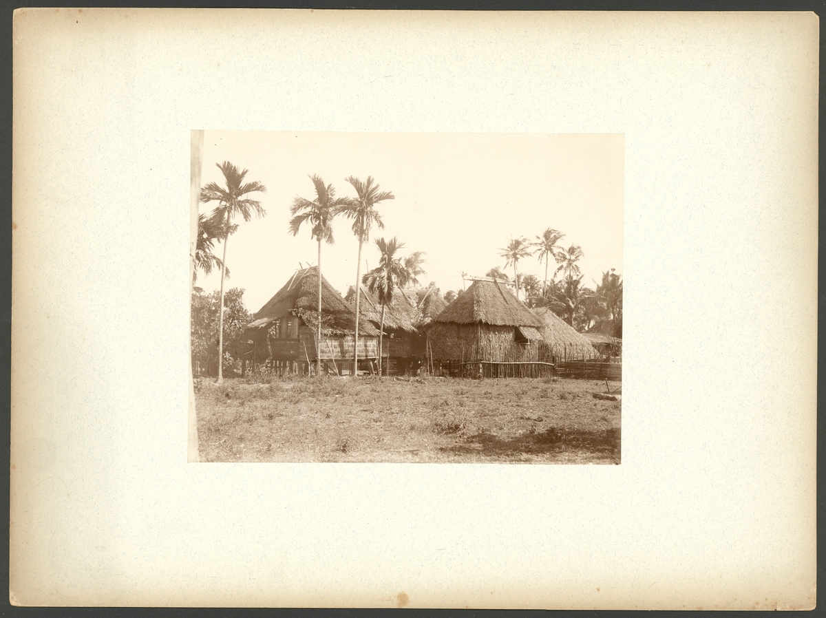 Bilden visar en by med enkla hus av trä och palmblad på Filipinernas största ö Luzon.