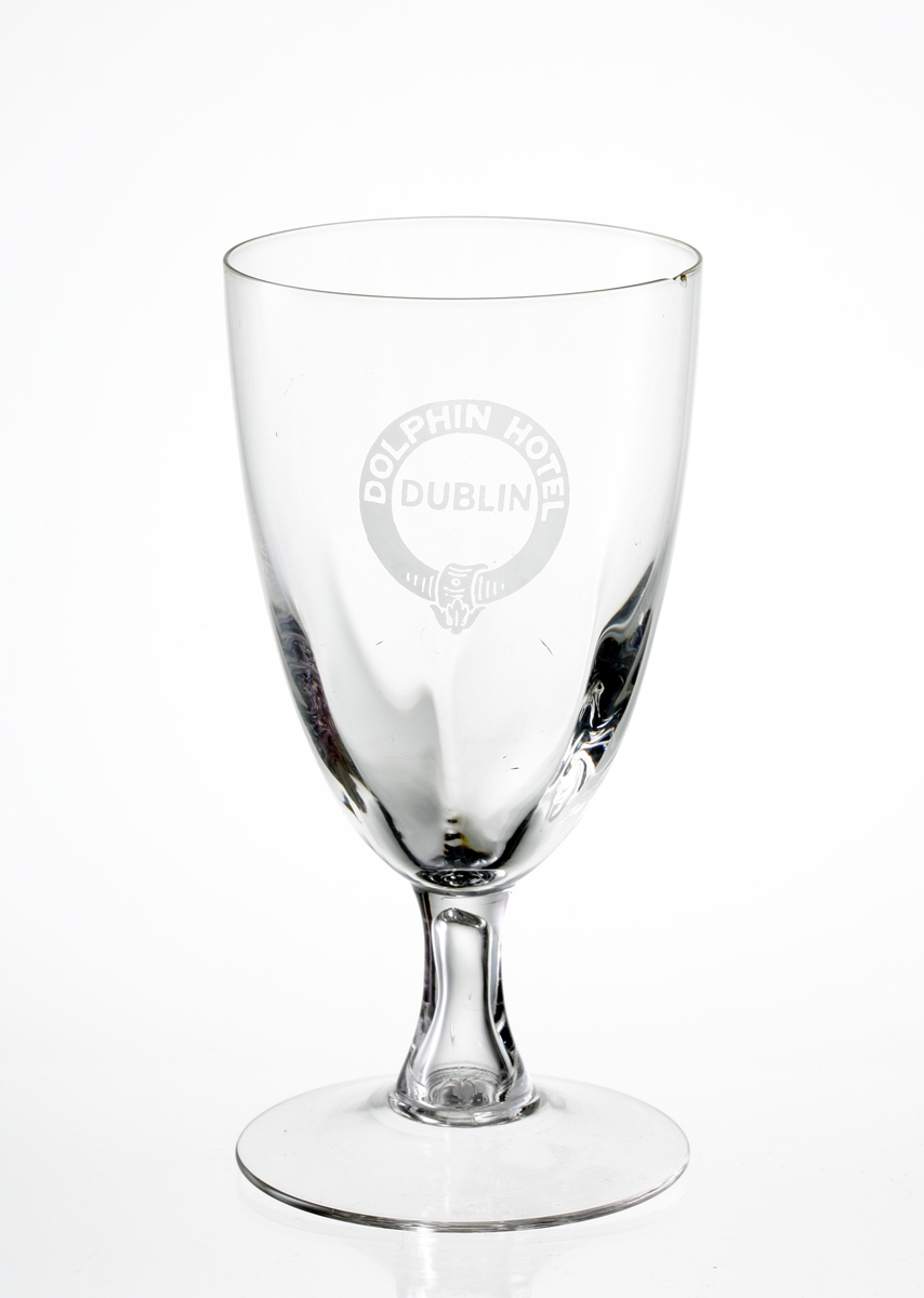 Design: Okänd. 
Ölglas på ben och fot. Optikblåst kupa med etsat emblem: "Dolphin Hotel, Dublin".