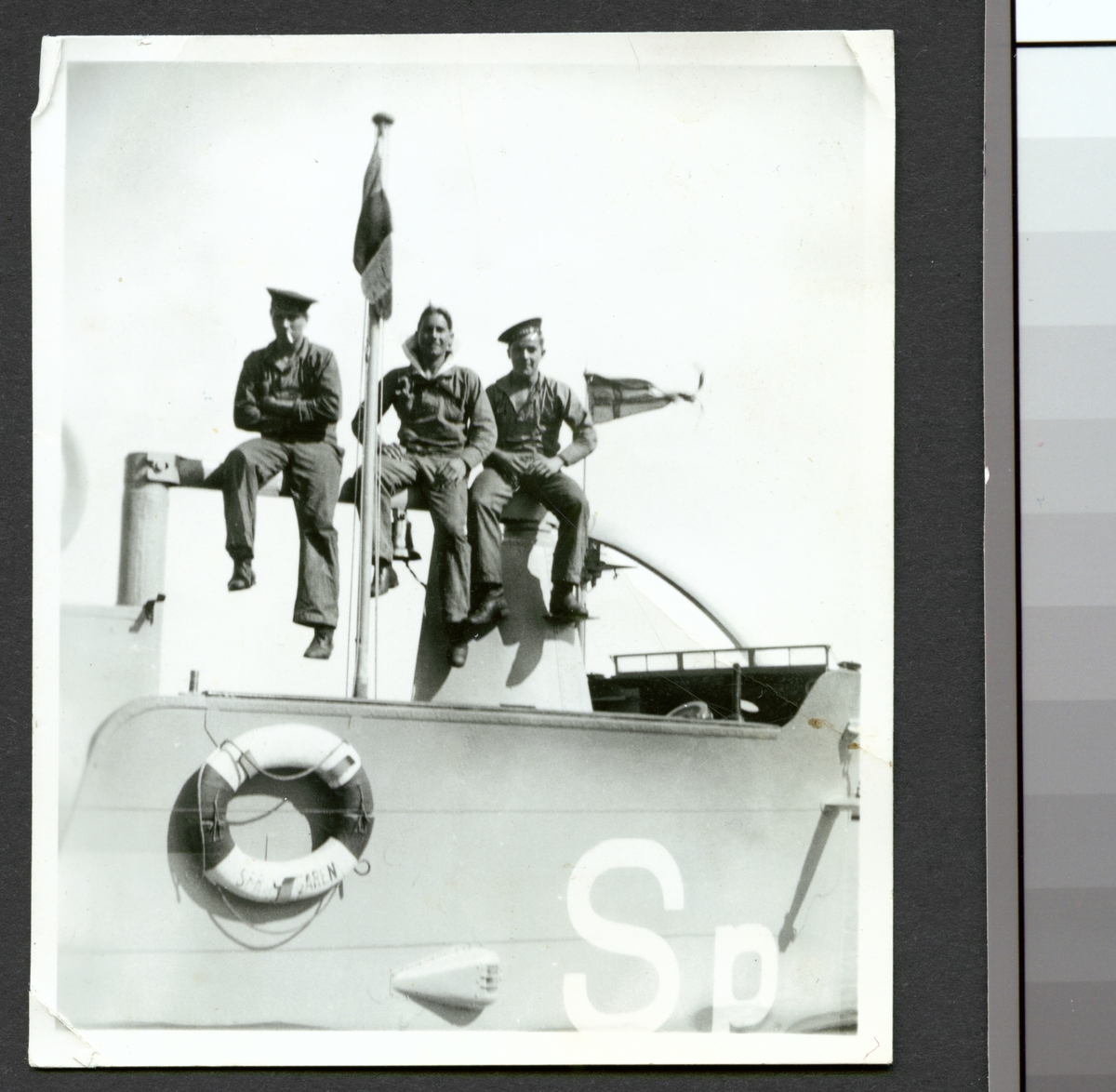 Bilden visar tre sjömän som sitter uppe på tornet av ubåten Springaren.