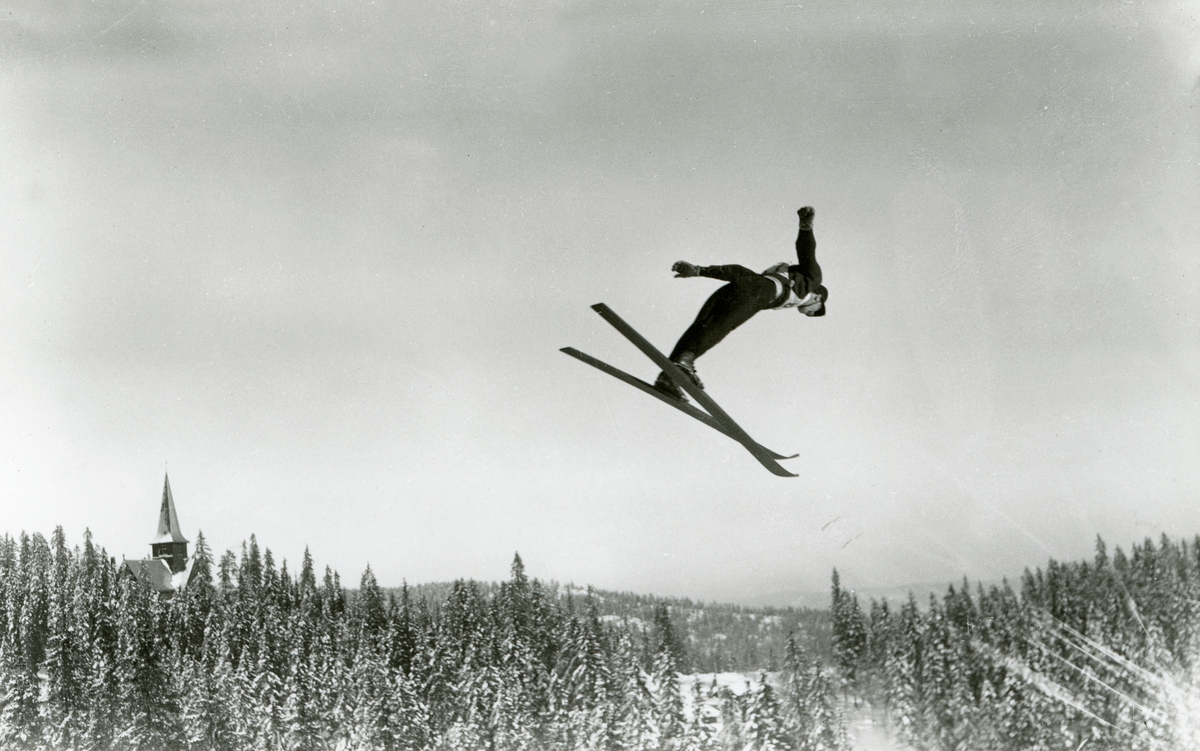 Holmenkollrenn. 1934. Hopper i svevet. Nordmarka og Holmenkollen kapell ...