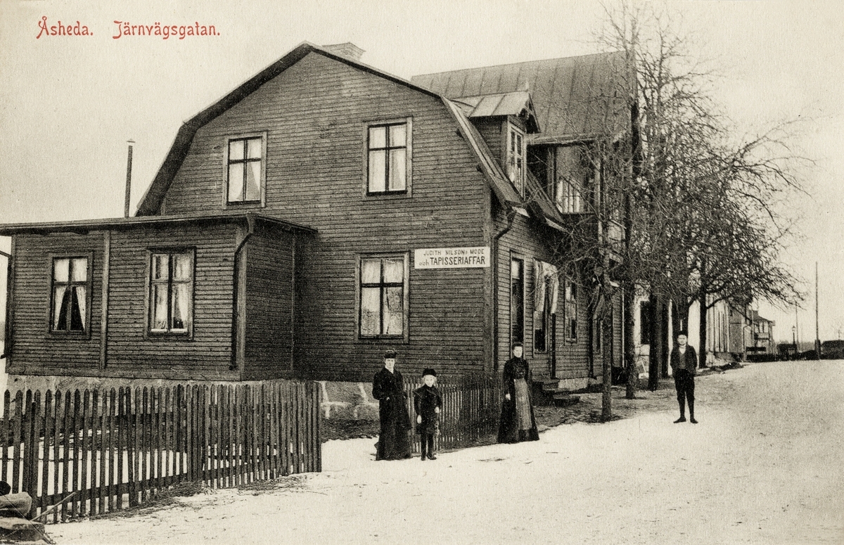 Bostadshus m.m., Järnvägsgatan, Åseda, ca 1902. I huset i förgrunden inrymdes "Judith Nilssons Mode och Tapisseriaffär".