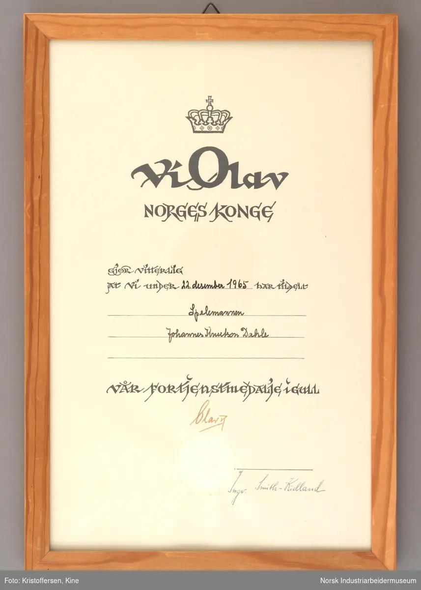Innrammet diplom av kongens fortjenstmedalje i gull tildelt spelemannen Johannes Dahle.