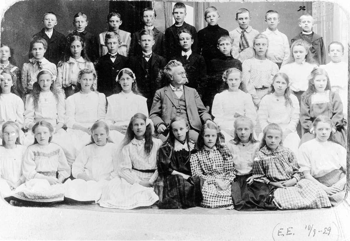Organist och folkskollärare Karl Karlberg med sin skolklass. "Från näst sista skolåret 1909". Längst bak till höger står Erik Edholm, amatörfotograf och anställd vid Alingsås Bomullsväveri.