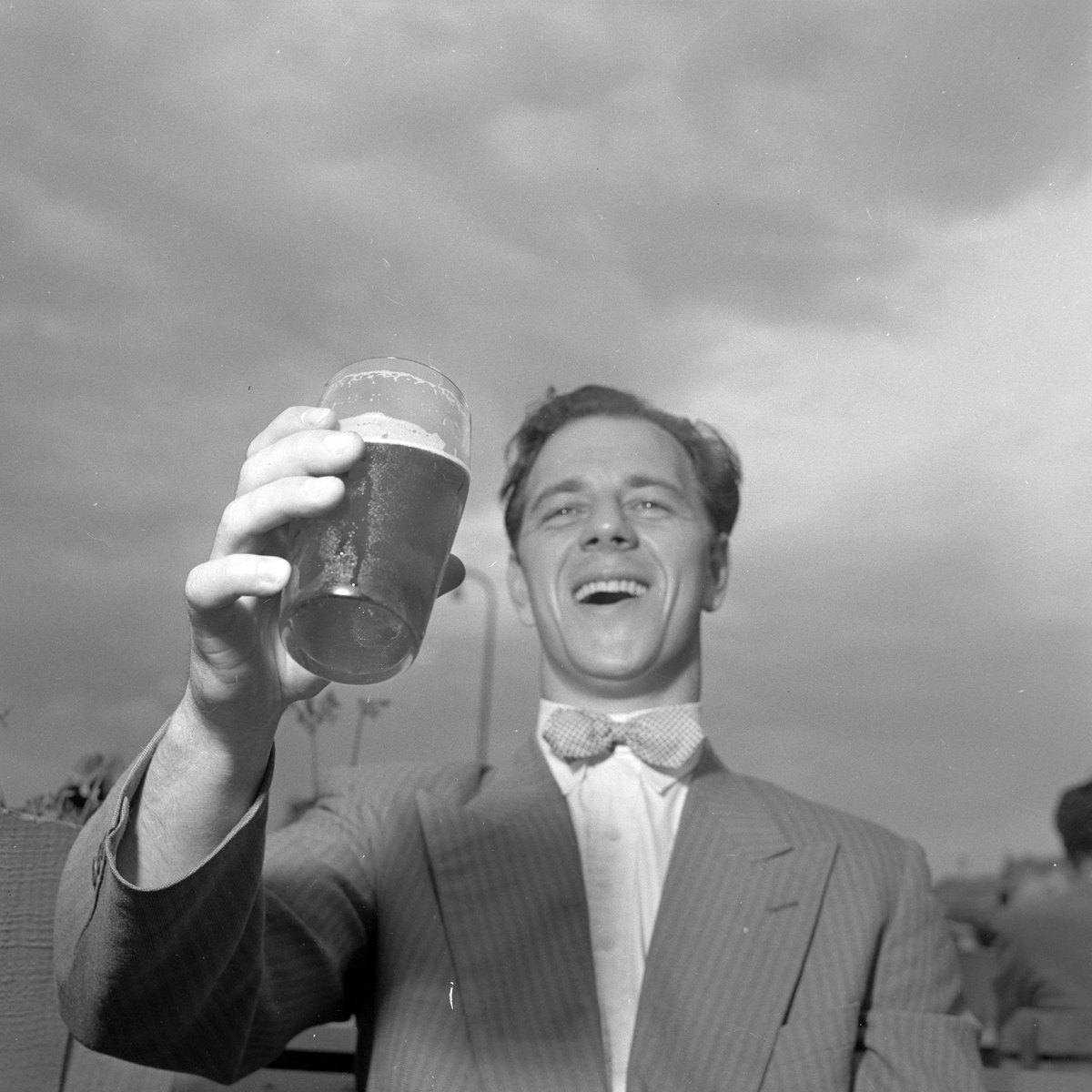 Mann nyter en øl på Skansen i sommervarmen
