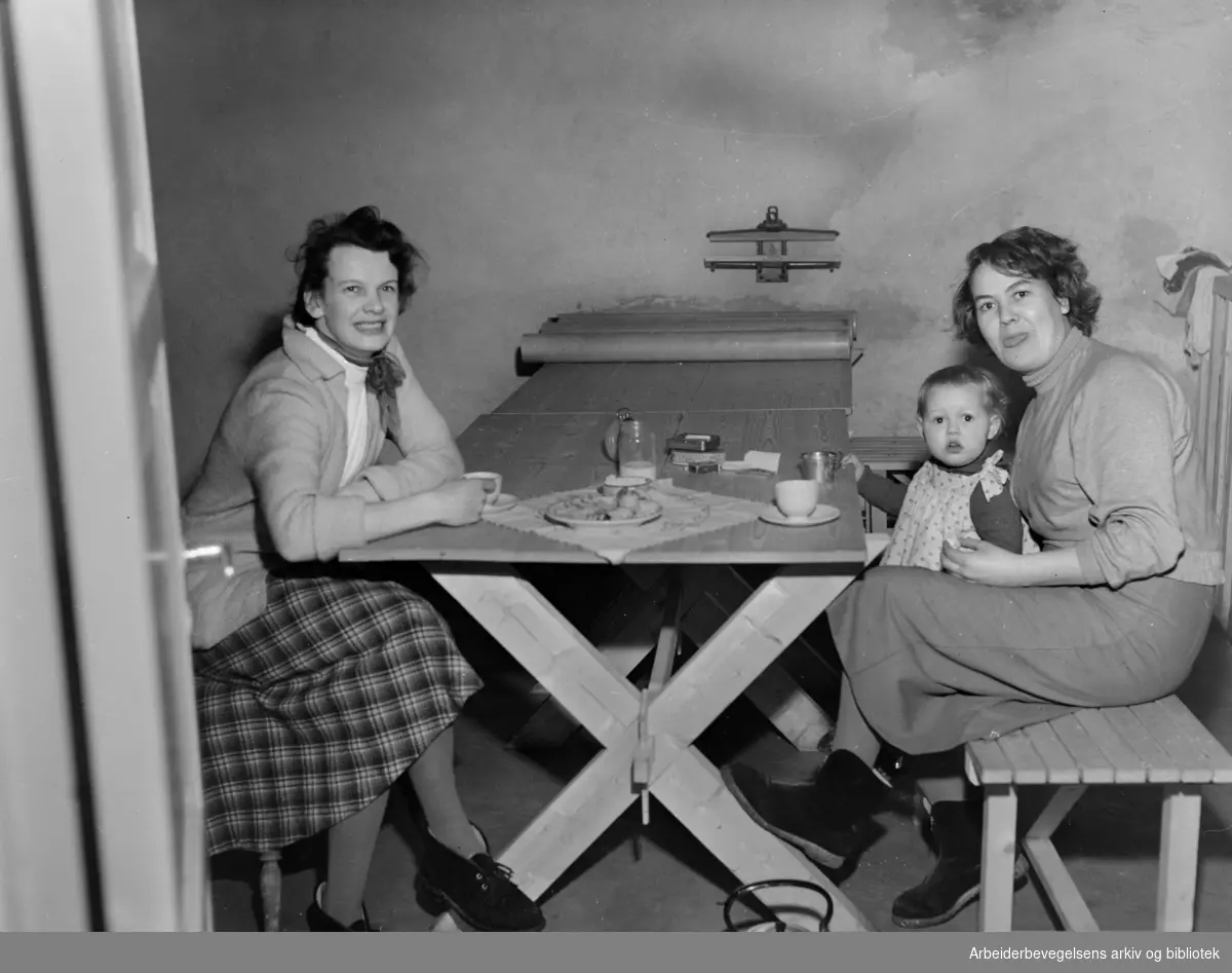Sigrid Kristiansen, lille Bente og Eva Pedersen i en vaskejeller i en av stjerneblokkene på Grorud. Februar 1954