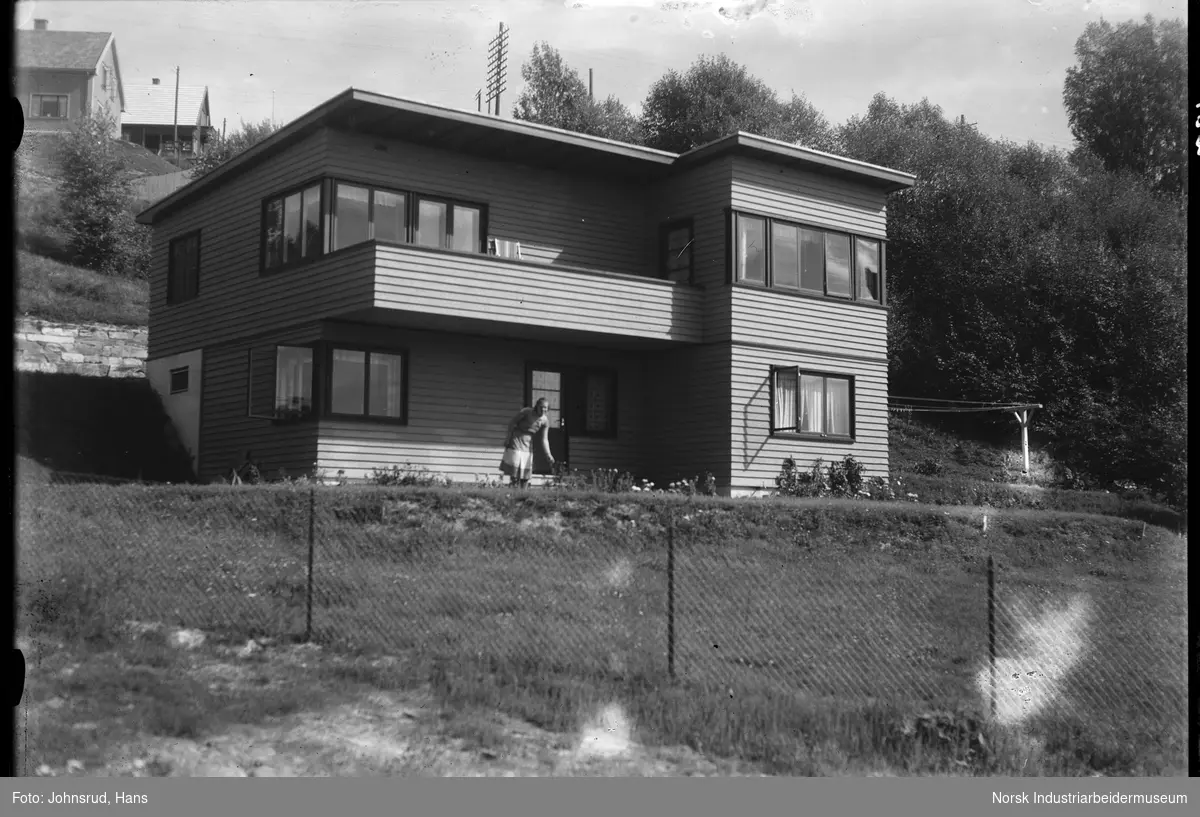 Fotograf Hans Johnsruds bolighus, kvinne stående i hagen.