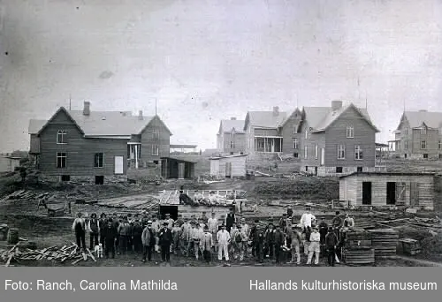 Egnahemsförening, på Östermalm, bildad av anställda vid järnvägen Varberg-Borås. På bilden arbetare och arbetsledare, eventuellt blivande ägare framför en del av villorna. Från 1905-1906. Se VMA8828 för fler uppgifter.