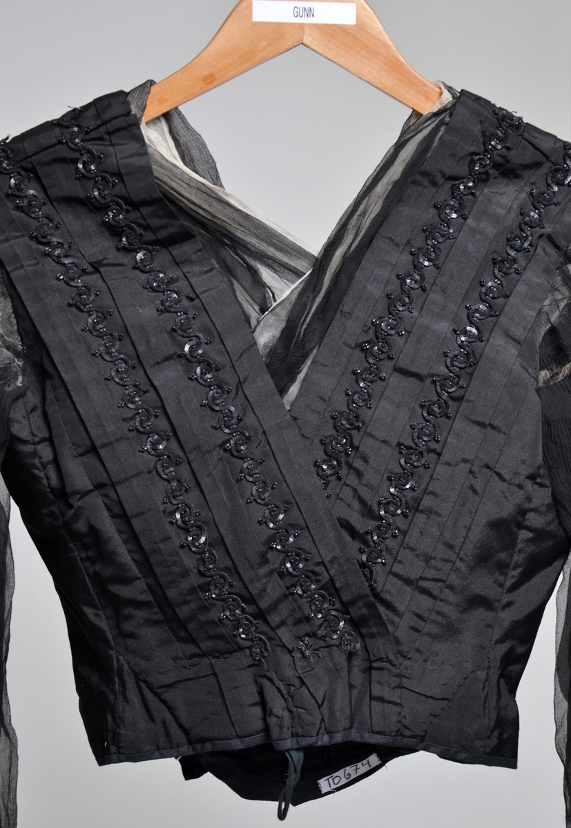 Sort bluse dekorert med sorte perler og paljetter på bolen og ermer og "krage" av sort og hvitt chiffong