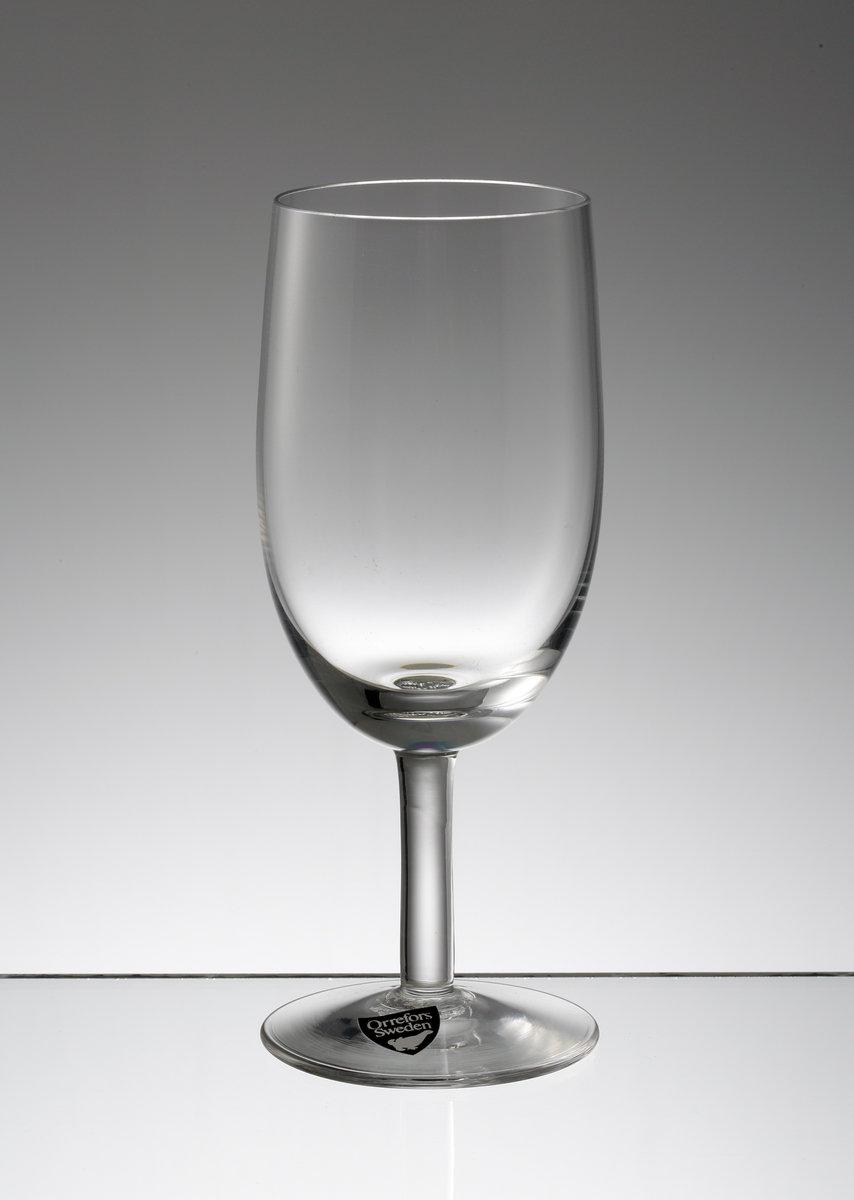 Design: Nils Landberg.
Vitvinsglas. Ovoid slät kupa med stråben.
Fabriksmärke: mörkgrå botten med vit text.