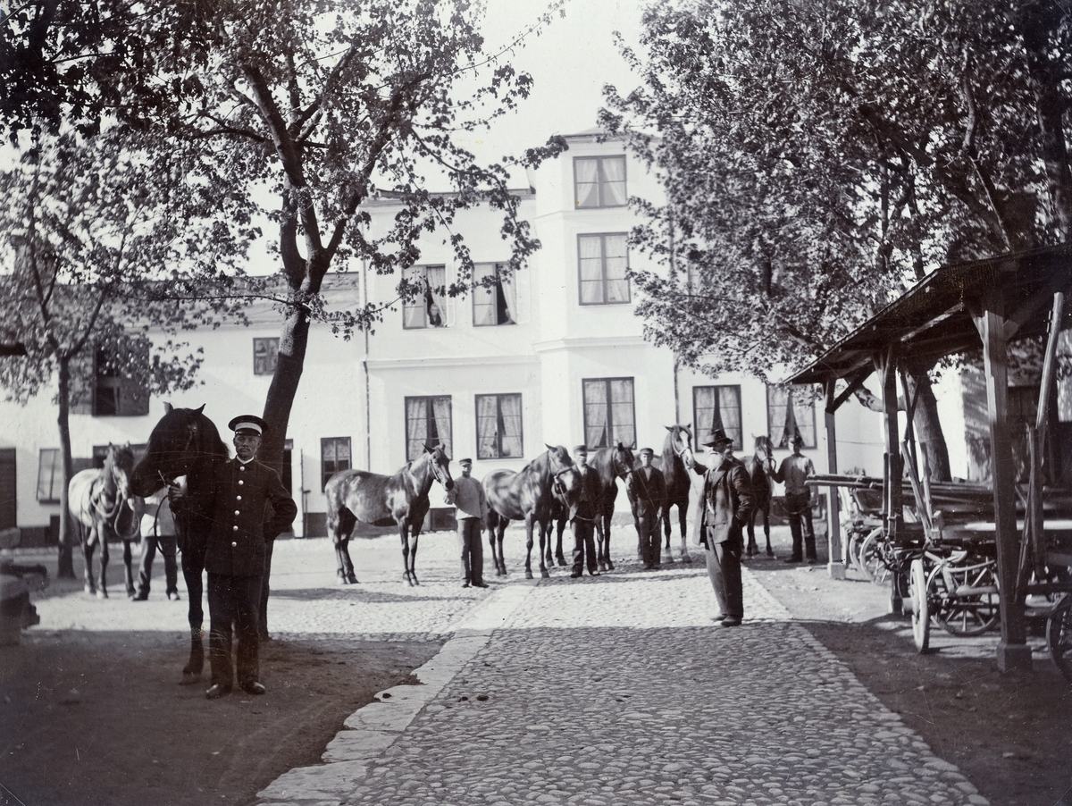 Åkeri, Växjö, kv. Blenda (?), ca 1900. 
Mannen i mitten är den s.k. "Snus-Lundgren", med affär och bostad på Sandgärdsgatan 17.
Till vänster står kusken (senare åkaren) Erland Erland.