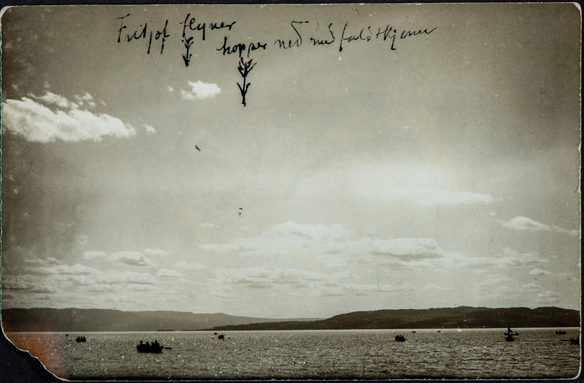 Fritjof Løberg hopper ut av et fly, med fallskjerm over Mjøsa. Hamar. Båter