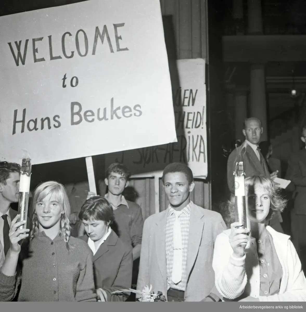 Hans Beukes, student fra Sør-Afrika, ankommer Oslo og blir tatt imot av studenter i fakkeltog på Universitetsplassen, september 1959.