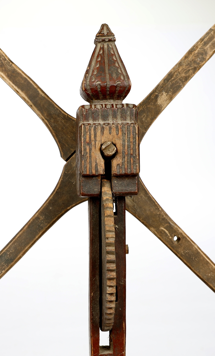 Hespetre med telleverk (basmehjul) og fire armer. Stativet er dekorert med utskjæringer. 
