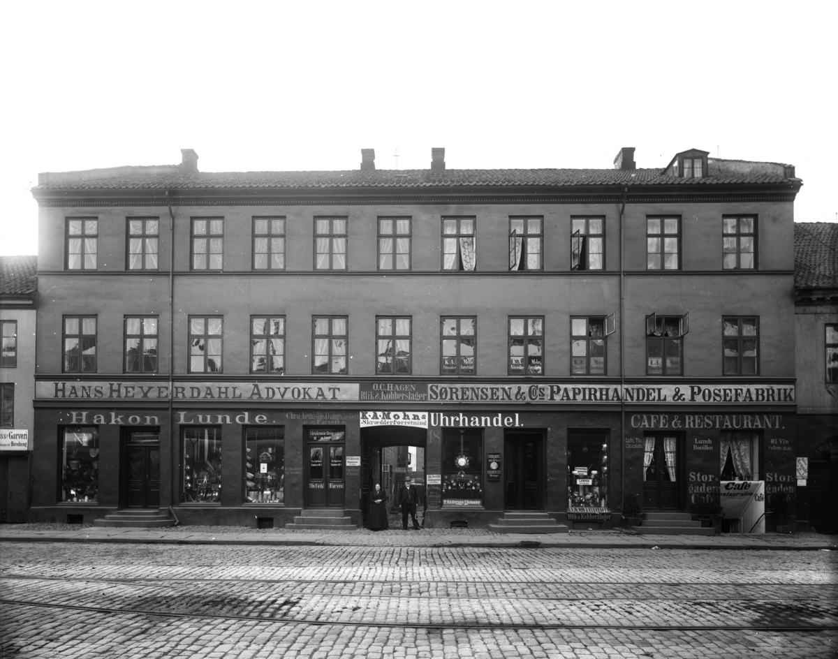 Bygning, sannsynligvis i Storgata 18, i Oslo. Skilt: hans Heyerdahl advokat, O. C. Hagen blik & koberslager, Sørensen og cos Papirhandel & posefabrik, Storgaden cafe og restaurant.