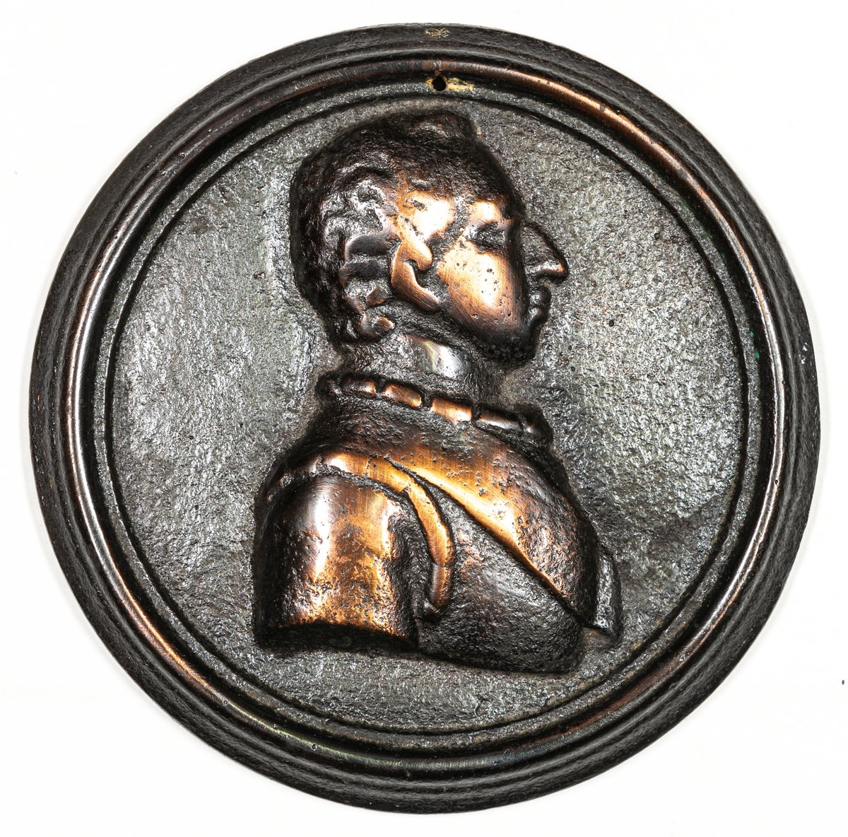 Medaljong, gjutjärn. Rund platta försedd med hål för fastsättning. I relief , bröstbild. Högerprofil av Gustav IV Adolph. På baksidan "GUSTAF IV ADOLPH" och märket ABSO.