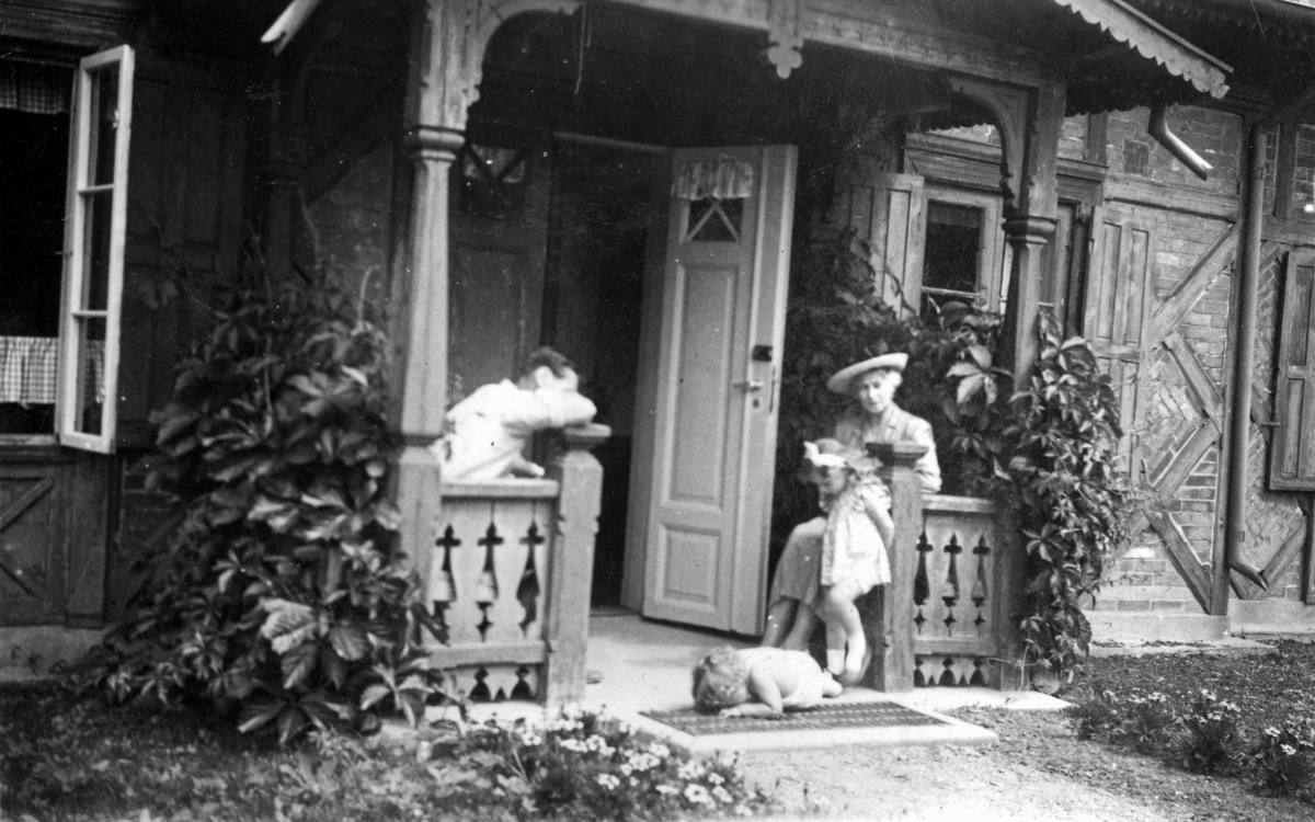 Overgartner Gösta Larsson, sønnen Stig og moren Else med ukjent jente på fanget på verandaen til gartnerboligen på Bygdø Kongsgård, antatt 1949.