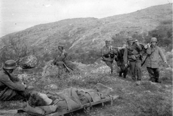 En såret soldat bæres på båre av medsoldater i den tyske kri