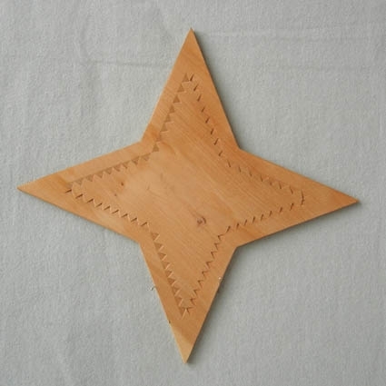 Bricka med formen av en stjärna fyra uddar och uddsnitt runt om. Brickan är obehandlad.