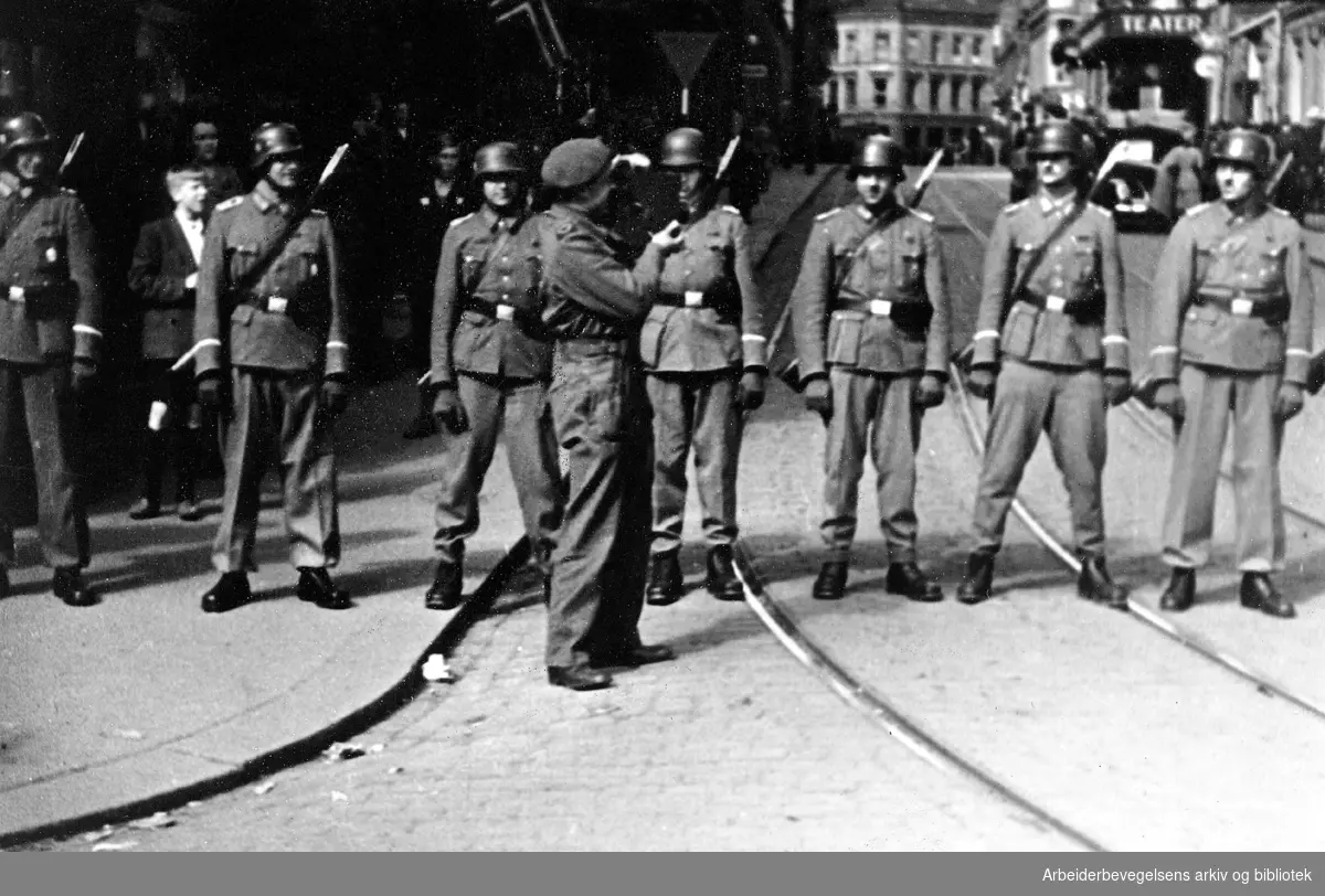 Tyske soldater fungerer som ordensvern i krysset Karl Johans gate/Rosenkrantz' gate under den spontane feiringen av frigjøringen, 8. Mai 1945