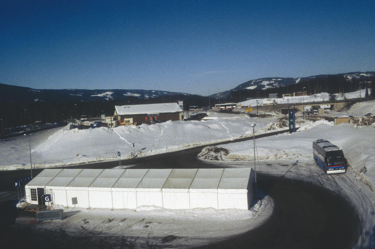 Lillehammer under OL 1994. Sannheim. Bussholdeplass. Telt for sjåfører. Lillehammervegen på bru over Moavegen i bakgrunnen. Foto mot nord-vest.