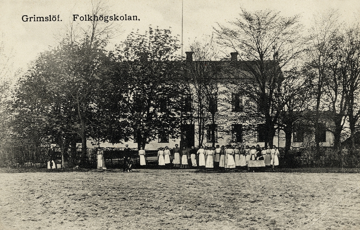 Grimslövs folkhögskola, ca 1910. En grupp människor står framför skolbyggnaden.
