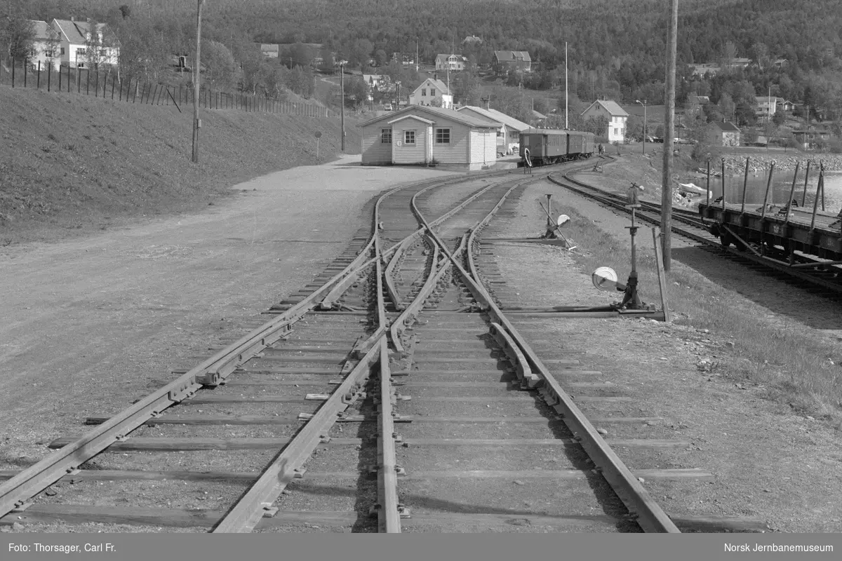 Sporkryss "engelskmann" på Finneid stasjon. I bakgrunnen Sulitjelmabanens motorvogn SULITELMA med persontog til Lomi