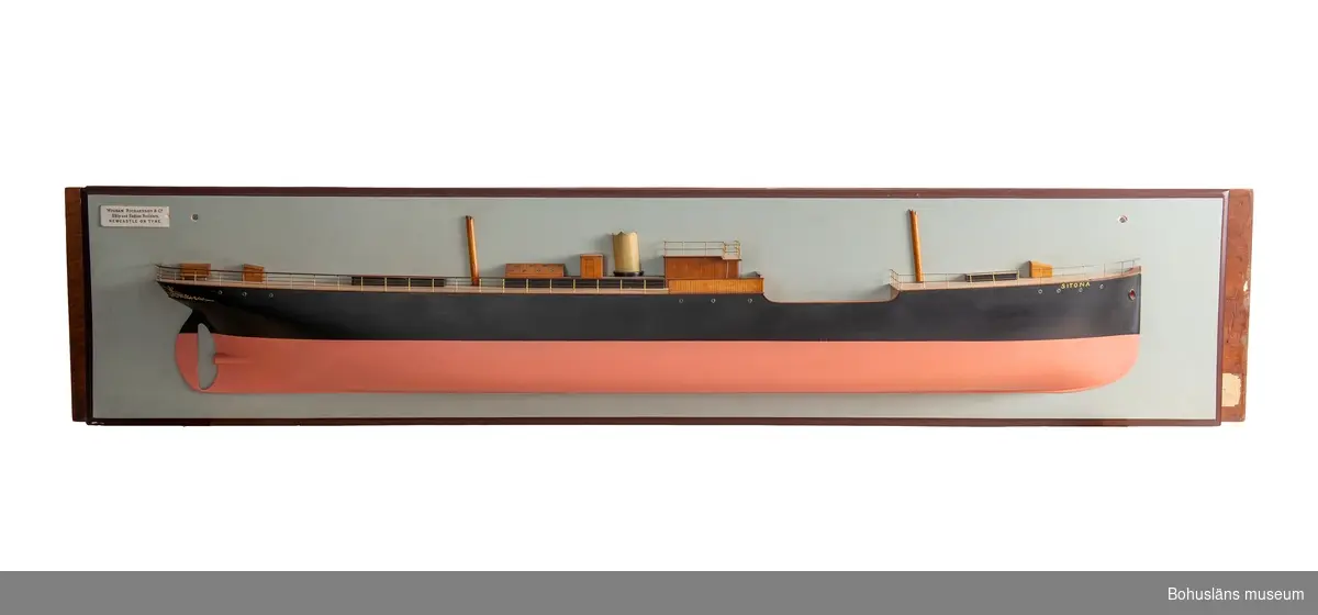 Halvmodell av ångskonerten S/S SITONA. 
Monterad på väggplatta med text: "WIGHAM RICHARDSON OCH CO. Ship and Engine Builders NEWCASTLE ON TYNE".
Skador på skorsten.