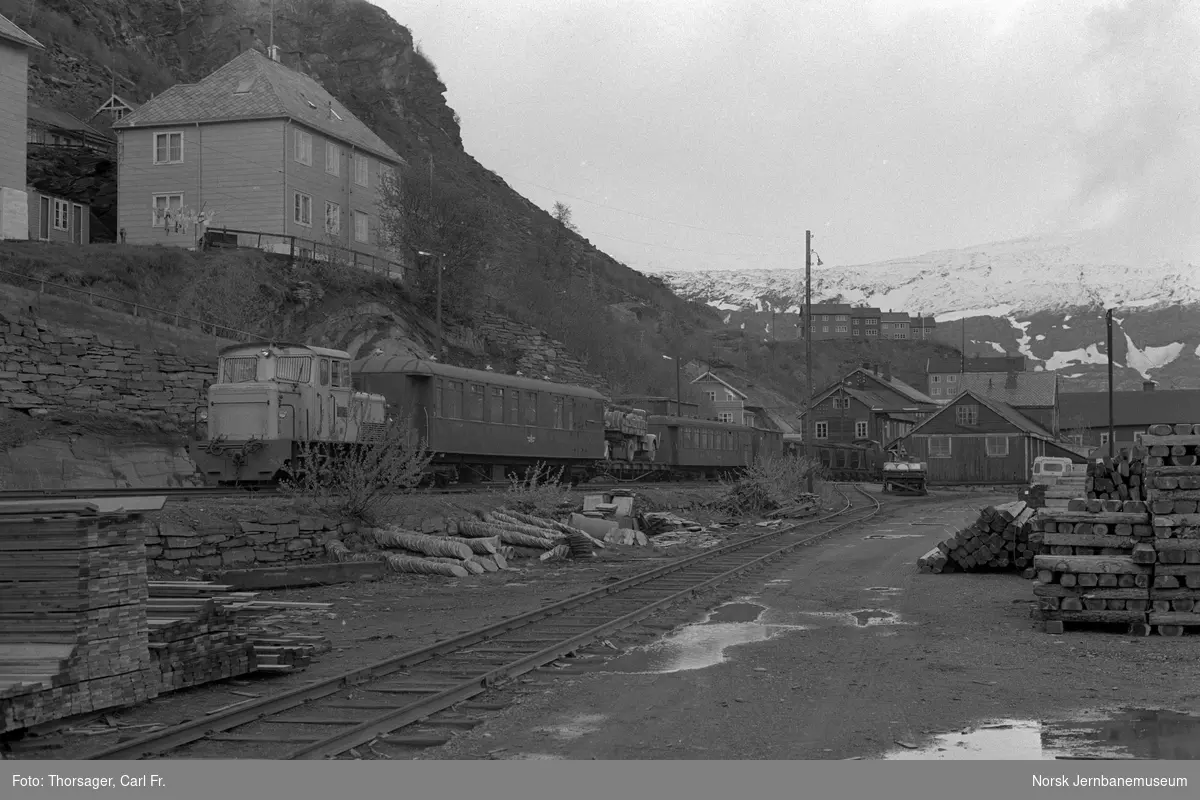 Sulitjelmabanens diesellokomotiv LOKE og personvogn BFo 7 med persontog ved Sulitjelma stasjon. I bakgrunnen SAULO med blandet tog