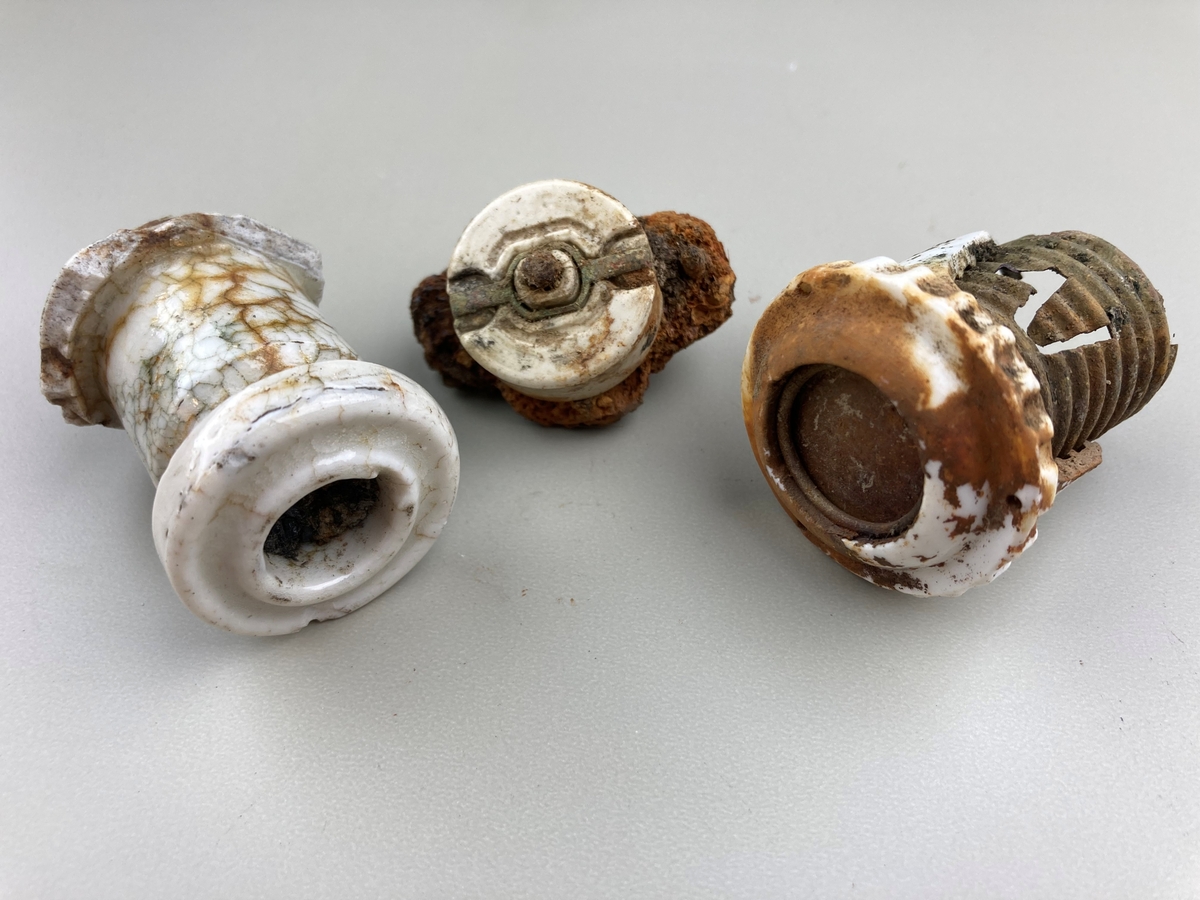 Tre gjenstander i porselen som har vært deler av elektriske artikler.