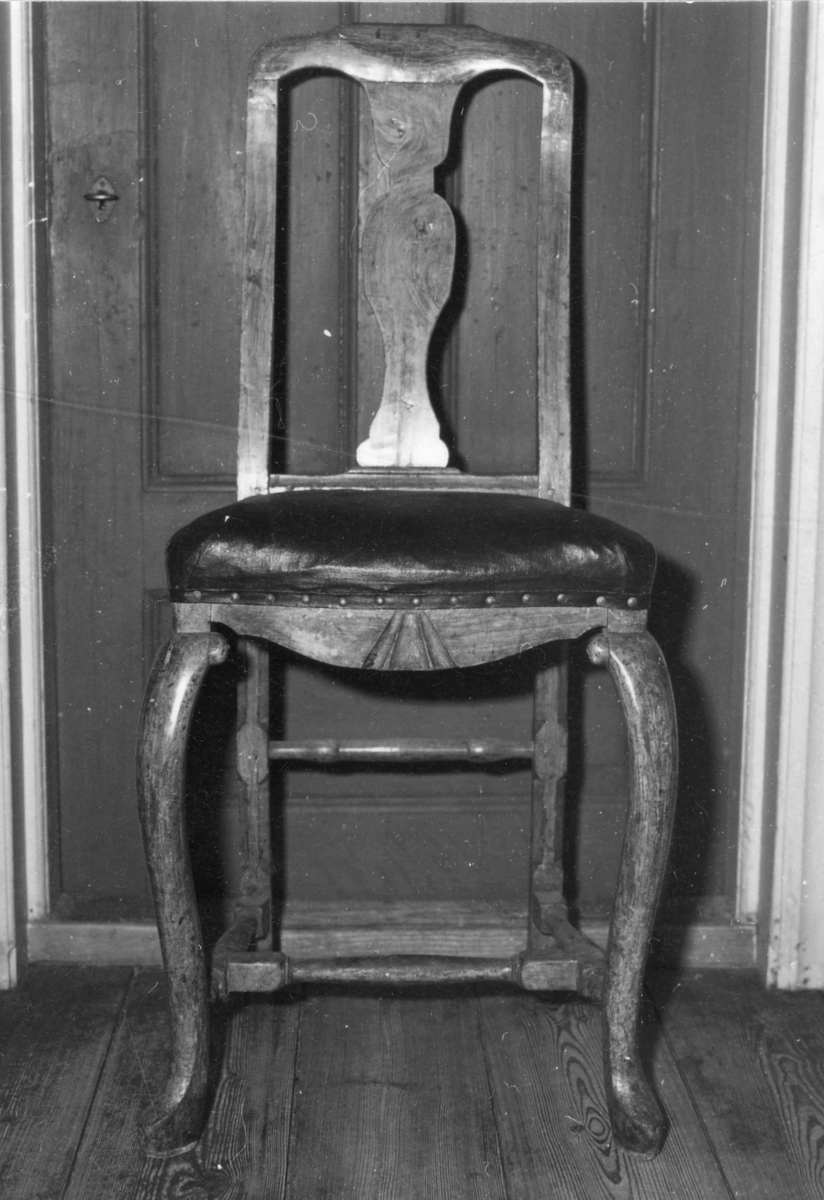 Gulmålad stol i senbarock med övergång till rokoko , svängda framben, svarvat benkryss samt svarvad tvärslå mellan bakben. Svängda bakben omväxlande 4-sidiga och 8-sidiga. Genombruten ngt bakåtsvängd rygg med svängdt krön och balusterformad vertikal bricka.
Var tidigare placerade i Skara Sessionssal men övertogs vid 1800-talets mitt av Skara Domkyrka.