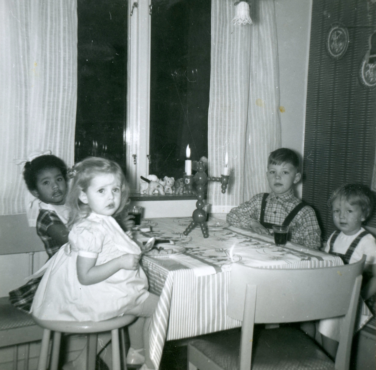 Jul i Villa Maribo. Fyra små barn sitter runt köksbordet. Främst från vänster: Lena Levén och Susanne Kullbring. Främst från höger: Manne Ekman och Anders Nordström.