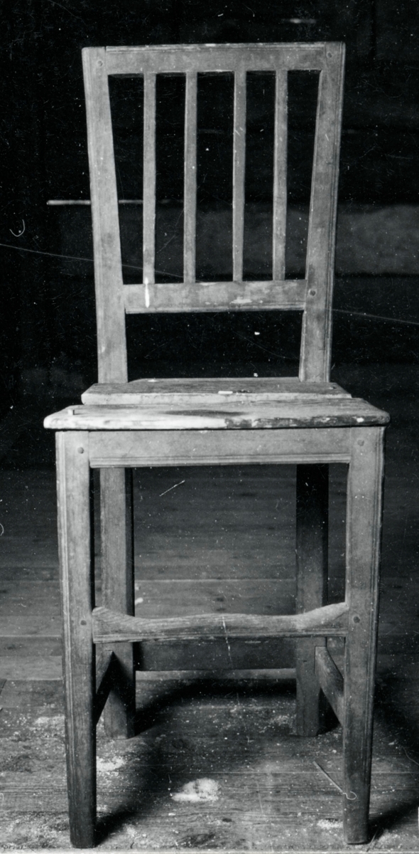 Brunmålad stol med 4 spjälor i ryggen, raka 4-sidiga ben med tvärslå.