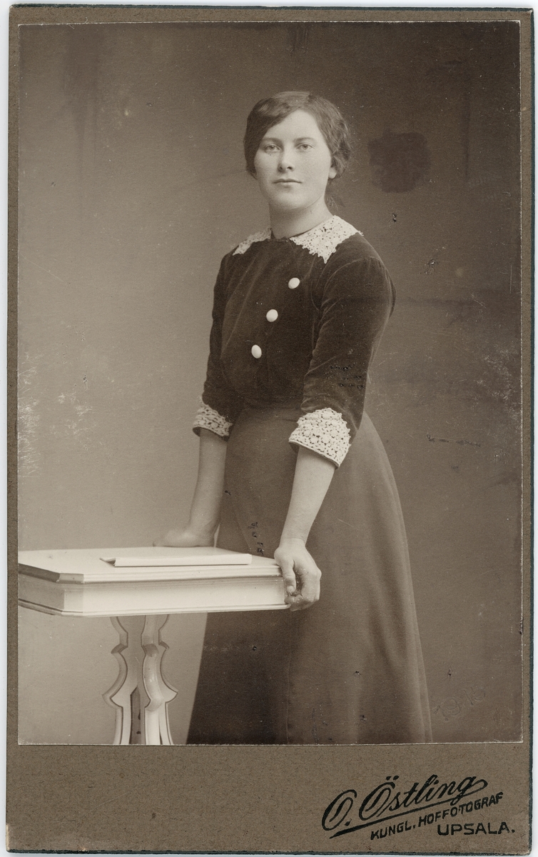 Kabinettsfotografi - kvinna vid ett bord, Uppsala 1915