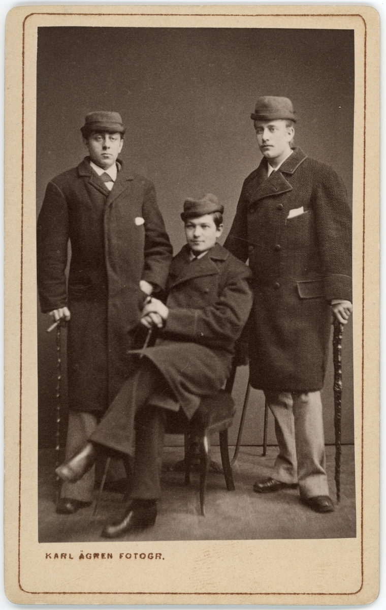 Kabinettsfotografi - herrarna Westman, Rydin och Öhrwall i överrock och hatt, Uppsala 1880