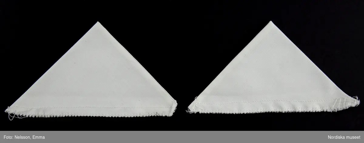 Två vita trekanter sydda av dubbelt tyg. Att använda på kragen vid sorg.