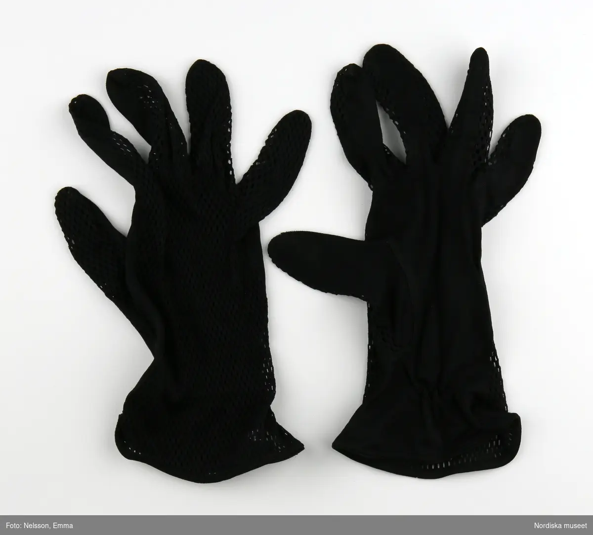 Tunna svarta handskar med nättyg på ovansidan av handen. vid handledens insida en kort resår fastsytt med sicksack.
/Magdalena Fick 2012-05-21