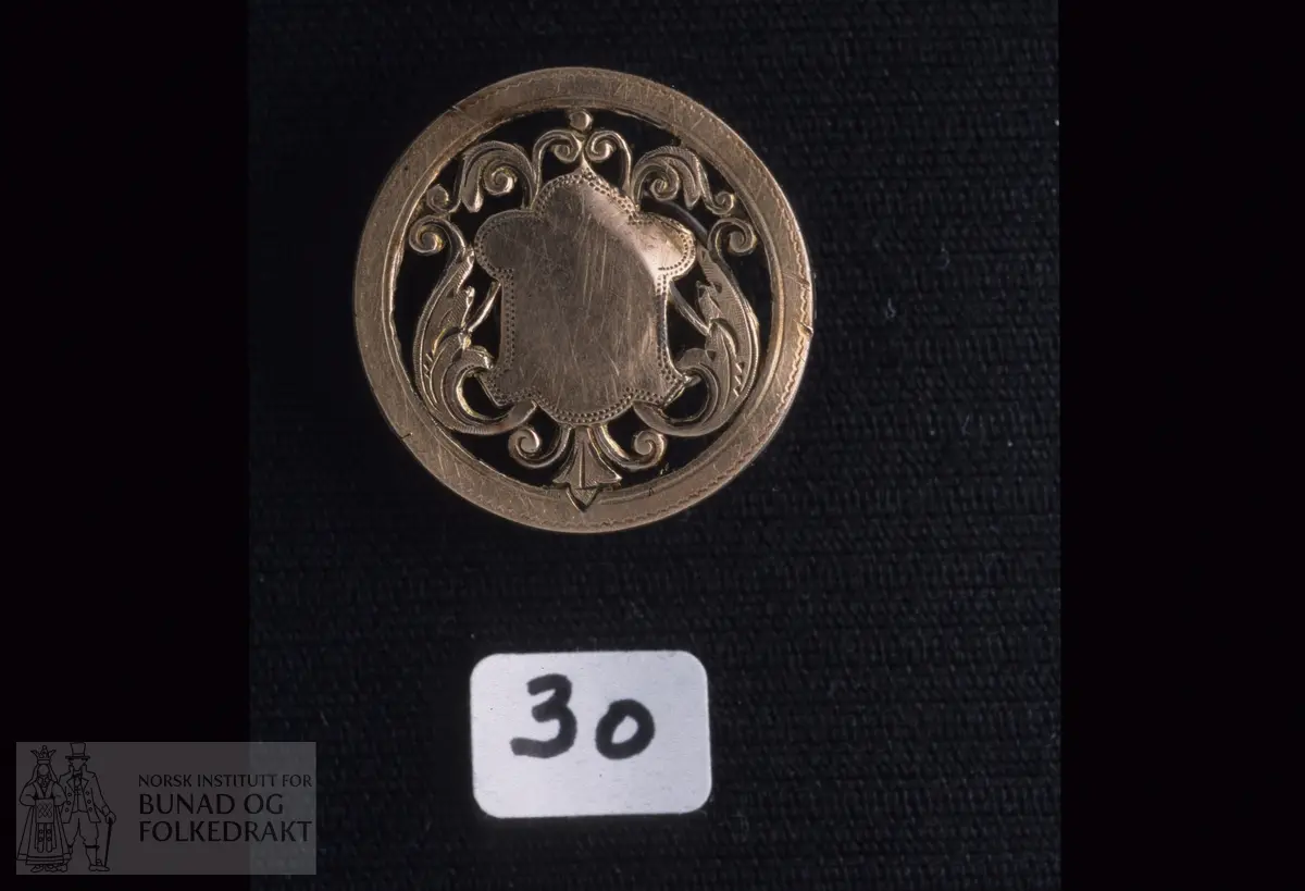 Oppl.: "Ca. 90 - 100 år".   Mønstra metallknapp med pålodda stetteknapp på baksida.  Diameter:  2,2 cm.