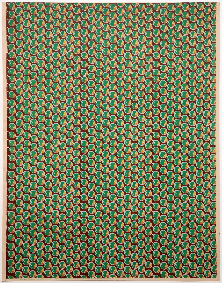 Rektangulært dekorativt papir med mønsteret "Frugter". Forsiden er dekorert med et repeterende mønster av stiliserte fruktformer i grønt, gul og orange - omgitt av blekgrønne konturlinjer - på brunfarget bunn.