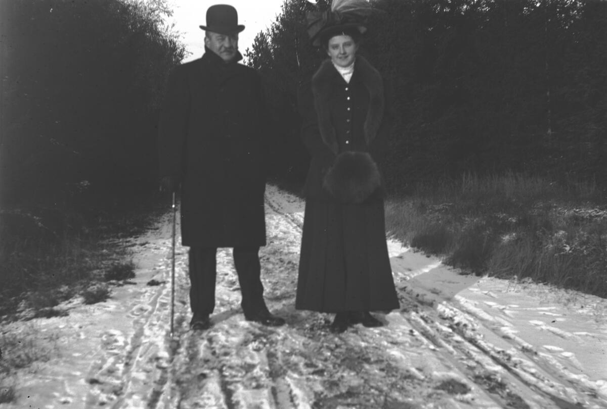 En man och en kvinna står på en snötäckt väg.