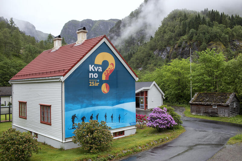 Bjørn West huset med gatekunst på ein side med tekst som seier "Kva no" med eit stort spørsmålsteikn