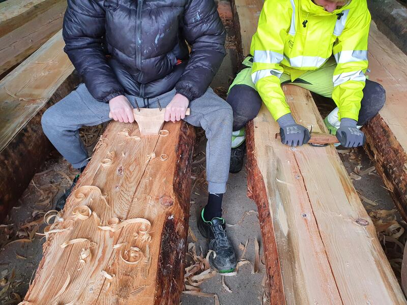 Her brukes en pjål for å bearbeide tømmeret. Den blir dratt langs stokken for å få en glattere overflate. Foto: Sverresborg, Trøndelag folkemuseum (Foto/Photo)